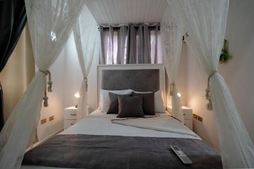 a bedroom with a canopy bed with white drapes at Casa MIKONOS in Cartagena de Indias