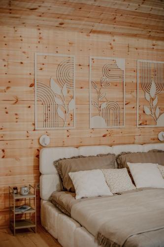 a bedroom with a wooden wall with a bed at WhiteWood Noszvaj in Noszvaj