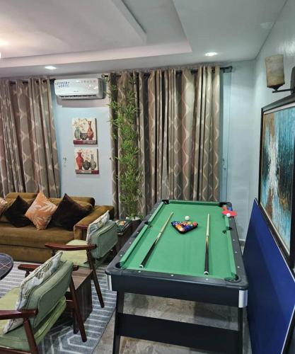 a living room with a pool table and a couch at Smartcribs 1 Bedroom Solar Powered Apartment, GRA in Port Harcourt