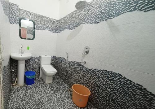 a bathroom with a black and white patterned wall at Hotel Saraswati Palace in Varanasi