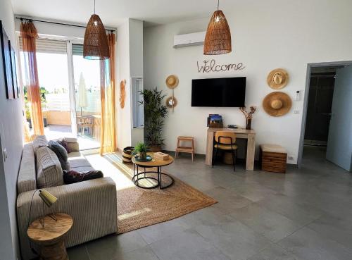 a living room with a couch and a tv at Bel appartement avec piscine en bord de mer in Ajaccio