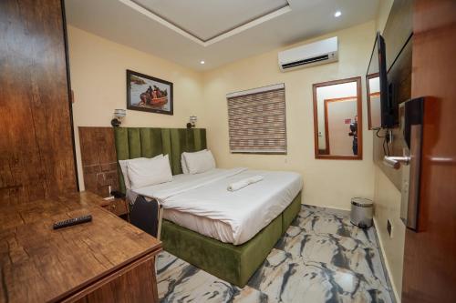 a hotel room with a bed and a television at Masters Class Apartments in Mama