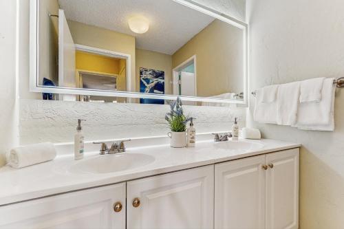 a bathroom with a white sink and a mirror at Plantation Hale D10 in Kapaa