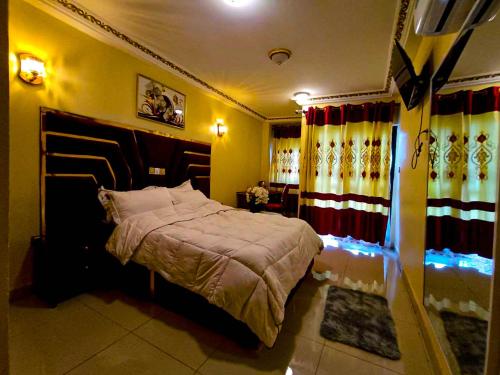 a bedroom with a bed in a room with curtains at Applegate Hotel in Yaoundé