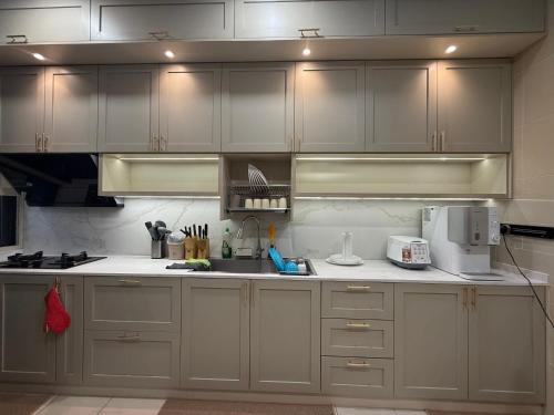 a kitchen with white cabinets and a counter top at The Garden Twelve Homestay in Putrajaya
