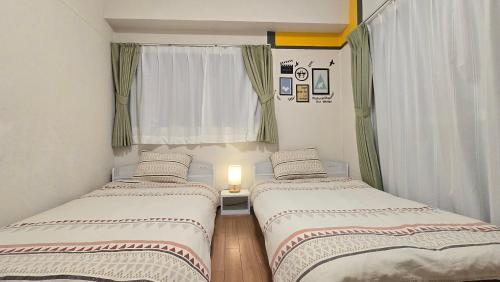 two beds in a small room with a window at Takamatsu-house201 in Shimminatomachi