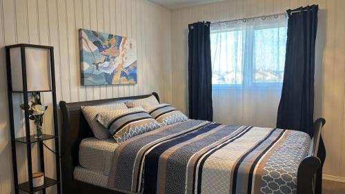 ein Schlafzimmer mit einem Bett und einem Fenster in der Unterkunft Casa Tarriela by Noel and Liza-Bungalow Upstairs in Edmonton