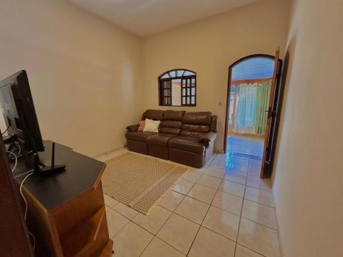 ein Wohnzimmer mit Sofa und Fernseher in der Unterkunft Casa na serra da Mantiqueira in São José dos Campos