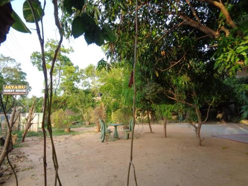 a park with a bench in the middle of trees at Jayaru Guest House in Polonnaruwa