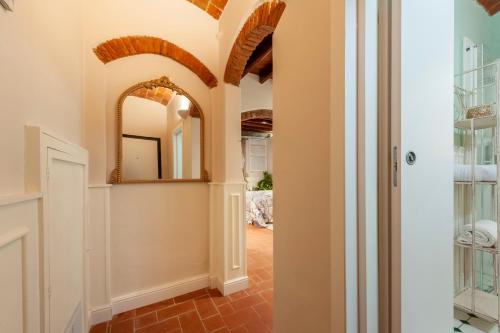einen Flur mit einem Spiegel an der Wand und einer Tür in der Unterkunft Elegante Appartamento a 2 passi dal centro storico in Florenz