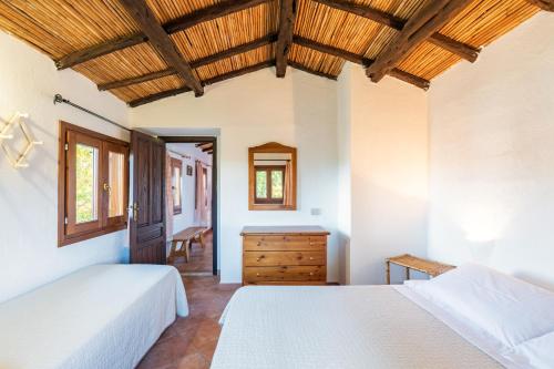 ein Schlafzimmer mit zwei Betten und einer Holzdecke in der Unterkunft Appartamenti Tiffany in San Teodoro