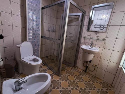 a bathroom with a toilet and a sink and a shower at Applegate Hotel in Yaoundé