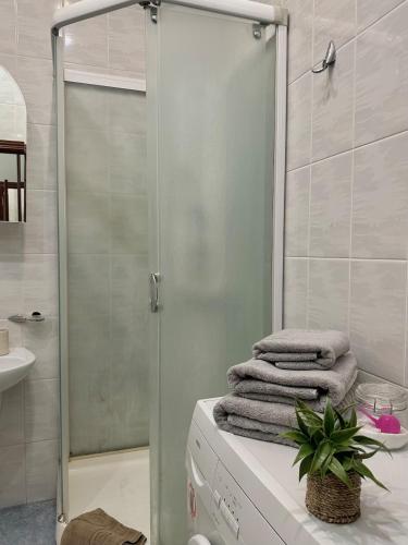 a bathroom with a shower with towels on a counter at 1 room right near the Kreschatyk in Kyiv