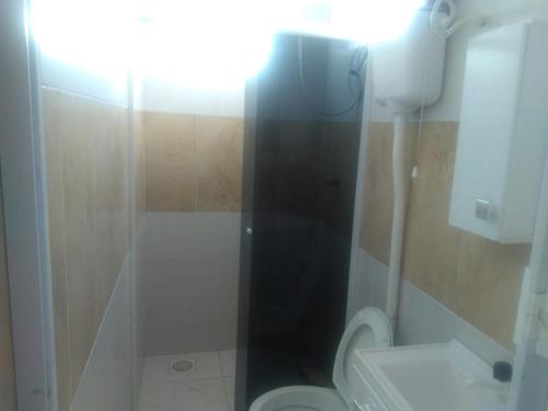 een badkamer met een douche, toilet en wastafel bij Residencial Roma AP01 in Capão da Canoa