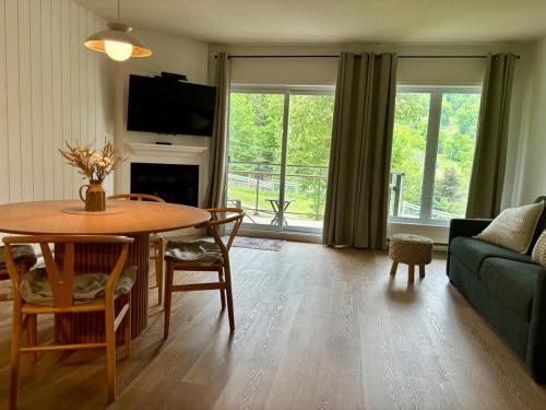 ein Wohnzimmer mit Tisch und Couch in der Unterkunft Ski in out condo sur la montagne in Bromont