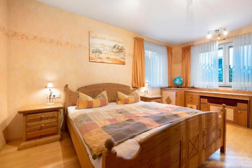 a bedroom with a large wooden bed and windows at Ferienwohnung Baier in Überlingen