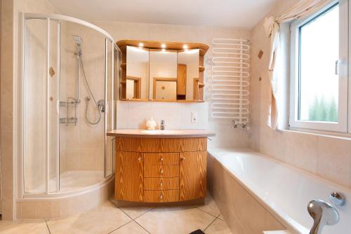 a bathroom with a tub and a sink and a shower at Ferienwohnung Baier in Überlingen