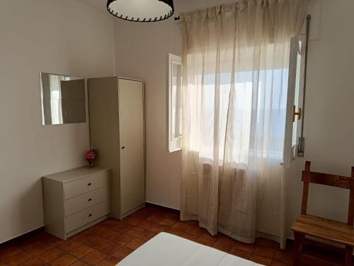 a bedroom with a dresser and a window with a mirror at Margareth suite and terrace in San Lucido
