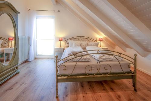 ein Schlafzimmer mit einem Metallbett im Dachgeschoss in der Unterkunft Jolie's Cottage in Iznang