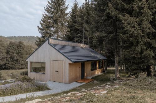 a small wooden house with a black roof at Wood Rest, MyWeek in Stronie Śląskie