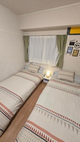 a row of three beds in a room at Takamatsu-house201 in Shimminatomachi