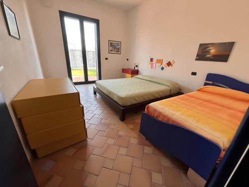 a bedroom with two beds and a window at Villa Gioconda a 200metri spiaggia Noto Calabernardo in Calabernardo