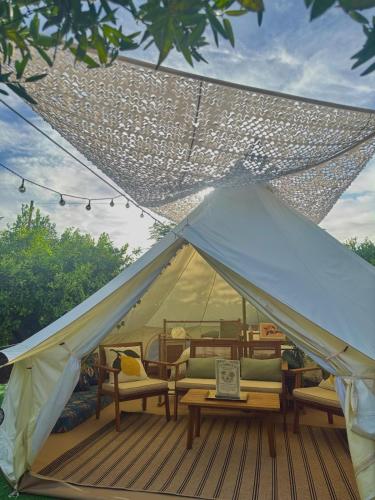 a white tent with chairs and tables on a deck at Glamping de Huerta La Arboleja in Murcia