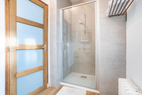 a shower with a glass door in a bathroom at Ce Petit Penty in Douarnenez