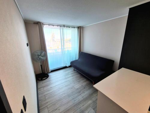 a small room with a blue couch and a window at Tu lugar ideal en el sector ideal de Santiago in Santiago