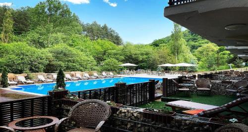 a view of a swimming pool with tables and chairs at Best Western Plus Paradise Hotel Dilijan in Dilijan