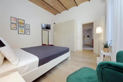 Un dormitorio con una cama y una silla verde. en Colosseo Mon Amour, en Roma