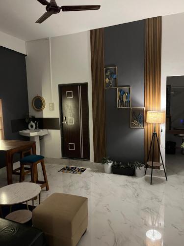 a living room with a couch and tables and a ceiling at Midtown Retreat in Dibrugarh