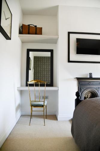 a bedroom with a chair and a mirror at White Fox House in Burgess Hill