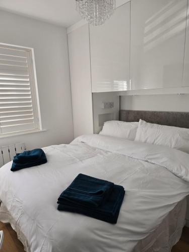 a white bed with two blue towels on it at By the Beach Perranporth, Truro, cornwall in Perranporth