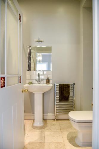 a white bathroom with a sink and a toilet at White Fox House in Burgess Hill