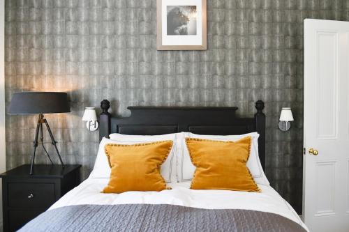 a bedroom with a bed with two yellow pillows at White Fox House in Burgess Hill