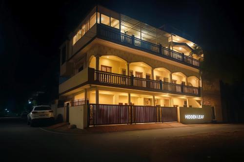a large building with lights on at night at Hidden Leaf in Dehradun