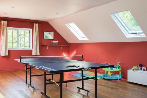 a ping pong table in a room with red walls at Lower Marsh Farm B&B in Saltash