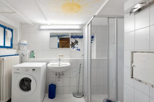 a bathroom with a washing machine and a sink at Haus am Ufer in Gaienhofen