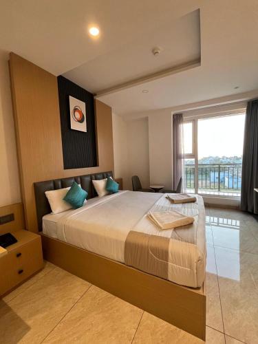 a bedroom with a large bed with a large window at Roots Luxury suits & Banquets in Bangalore