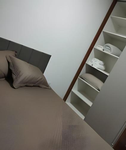 a bedroom with a bed and a book shelf at Rose Prime Loft – Executive Apartment in Extrema in Extrema