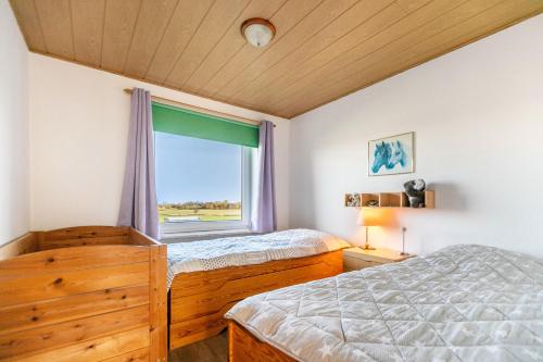 une chambre avec deux lits et une fenêtre dans l'établissement Whg 3 - Ferien auf einem Resthof, à Schönhagen