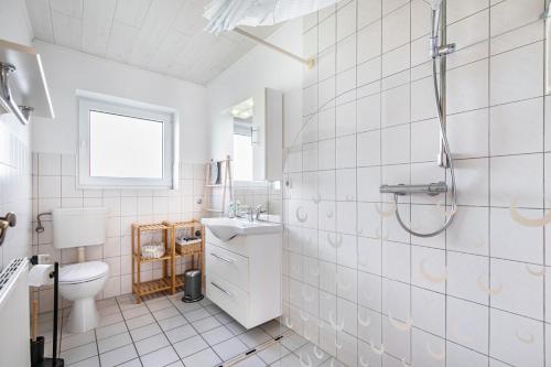 une salle de bains blanche avec toilettes et lavabo dans l'établissement Whg 4 - Ferien auf einem Resthof, à Schönhagen
