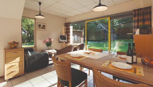 a kitchen and dining room with a table and chairs at Salland Duo Bungalows in Nieuw-Heeten