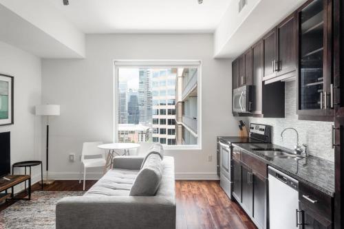 a living room with a couch and a kitchen at Kasa Lady Bird Lake Austin in Austin
