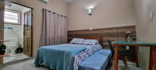 ein kleines Schlafzimmer mit einem Bett und einem Schreibtisch in der Unterkunft Chalé Vovó Zezé in Bertioga