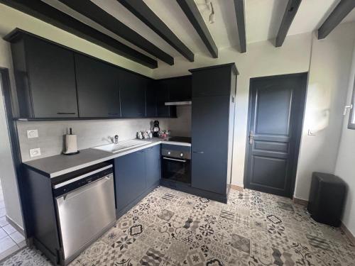 een keuken met zwarte kasten, een wastafel en een vaatwasser bij Loveroom Montargis in Montargis