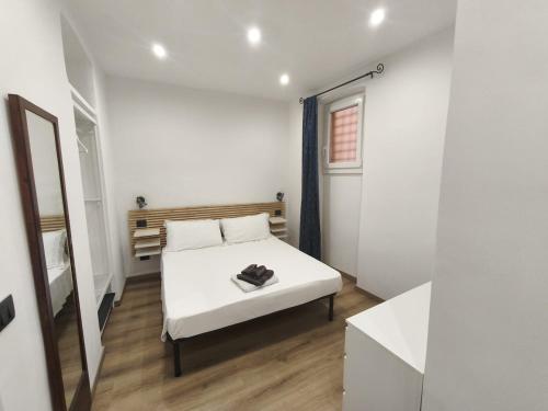 a white bedroom with a bed and a mirror at casa Mimi in Taggia