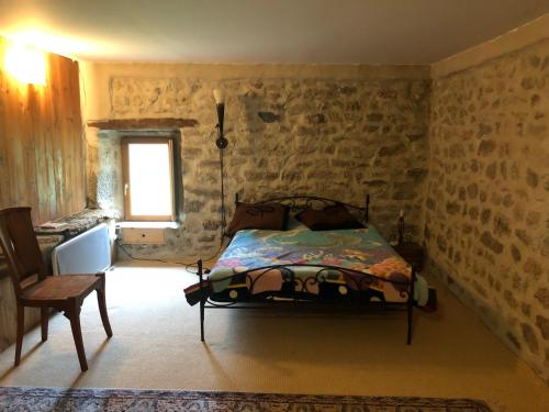 a bedroom with a bed in a room with stone walls at Maison sur le chemin de compostelle in Thoras