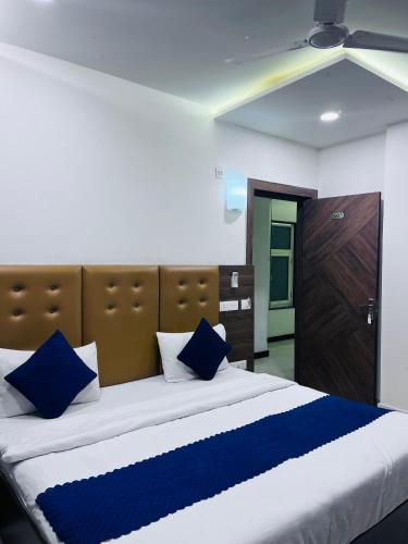 a bedroom with a large bed with blue pillows at Hotel MM Palace Vairo Cafe Rooftop View Taj Mahal in Tājganj